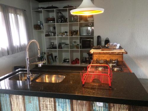 a kitchen counter with a sink with a basket on it at Linda casa na Gamboa Garopaba in Garopaba