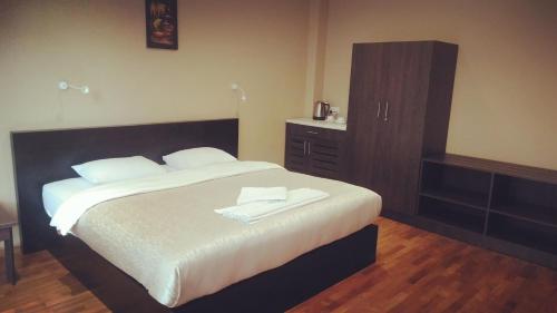 a bedroom with a large bed and a dresser at Panorama Green View Hotel Nuwara Eliya in Nuwara Eliya