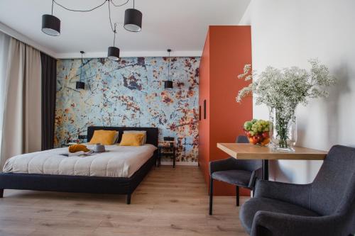 - une chambre avec un lit, une table et des chaises dans l'établissement W&K Apartments - Ginger Suite, à Koszalin