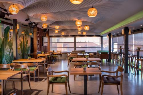 a restaurant with wooden tables and chairs and lights at Hotel Bograd - Apartments & Lounge Station in Struga
