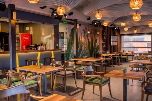 a restaurant with wooden tables and chairs and lights at Hotel Bograd - Apartments & Lounge Station in Struga