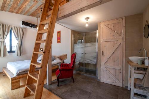 a bedroom with a loft bed and a bathroom at Gate Away B&B Units - המקום באל רום in El-Rom