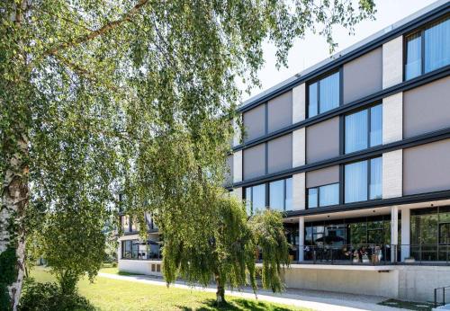 an office building with a tree in front of it at Das Altmühltal Hotel & Restaurant in Eichstätt