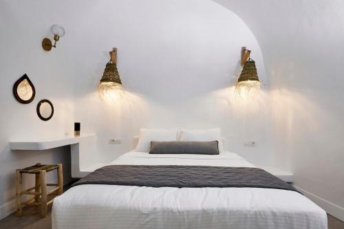 - une chambre avec un lit et deux lumières sur le mur dans l'établissement Luxury Santorini Villa Superior Cave Villa Outdoor Hot Tub Oia, à Oia