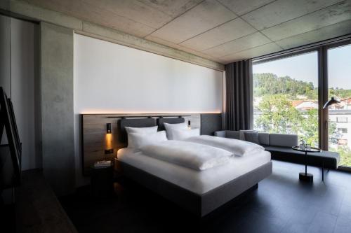 a bedroom with a large bed and a large window at Das Altmühltal Hotel & Restaurant in Eichstätt