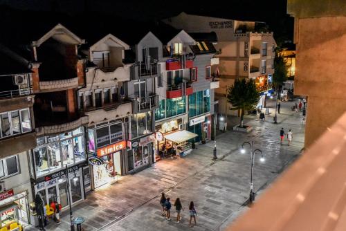 a group of people walking down a city street at night at Hotel Bograd - Apartments & Lounge Station in Struga