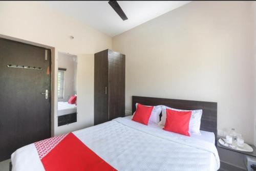 ein Schlafzimmer mit einem großen Bett mit roten Kissen in der Unterkunft La Villa Beach Paradise in Mahabalipuram