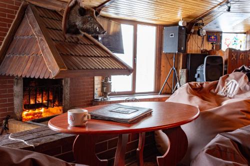 - une table basse dans le salon doté d'une cheminée dans l'établissement Хата Магната Hata Magnata, à Preluka