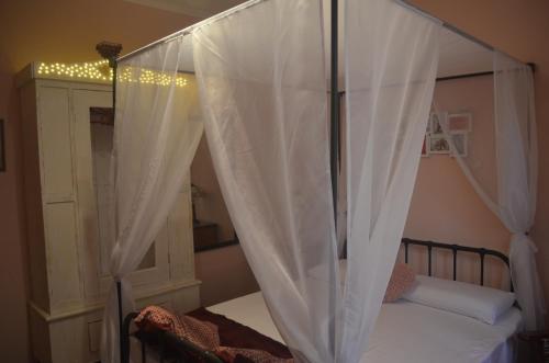 a white bed with a canopy over it at Casa Montegri 2 in Hal Ghaxiak