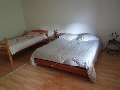 1 dormitorio con cama, mesita de noche y cama sidx sidx sidx sidx sidx en Les Plumes, en Asnans