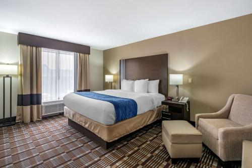 a hotel room with a large bed and a chair at Comfort Inn Sullivan in Sullivan