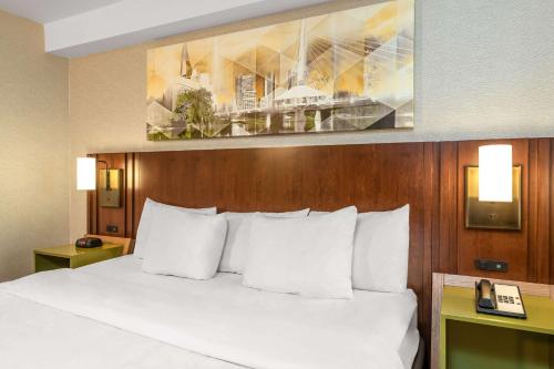 uma cama com almofadas brancas num quarto de hotel em Comfort Inn Boucherville em Boucherville