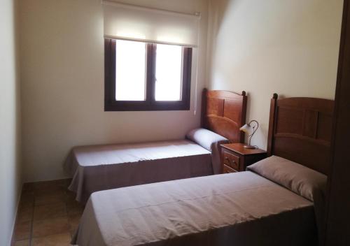 1 dormitorio con 2 camas y ventana en Torrehermosa Rural, en Torrehermosa