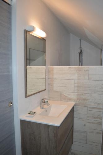 une salle de bain avec un lavabo et un miroir dans l'établissement Les Mansardes l'Appart, à Sarlat-la-Canéda