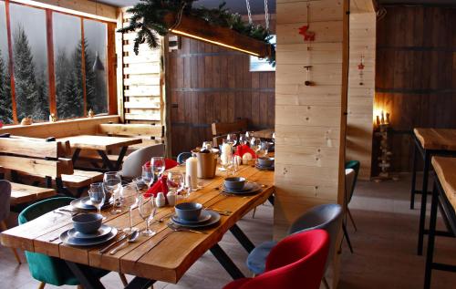 a dining room with wooden tables and red chairs at Chalet Vrhovi Kopaonika in Kopaonik