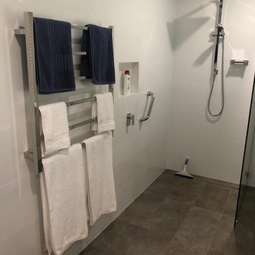 a bathroom with white towels and a shower at The Hideaway Luxury B&B Retreat in Armadale