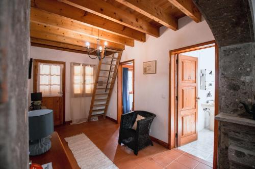 a living room with wooden ceilings and a stair case at Sete Cidades House in Sete Cidades