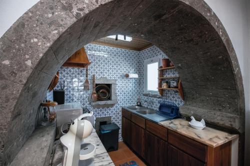 an archway in a kitchen with a sink and a stove at Sete Cidades House in Sete Cidades