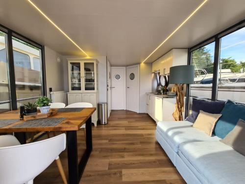 sala de estar con mesa y sofá en Otter Comfort klasse XL Houseboat, en Ophoven