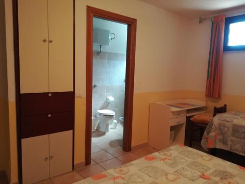 a bedroom with a bathroom with a toilet and a shower at L'Oasi in SantʼAntìoco