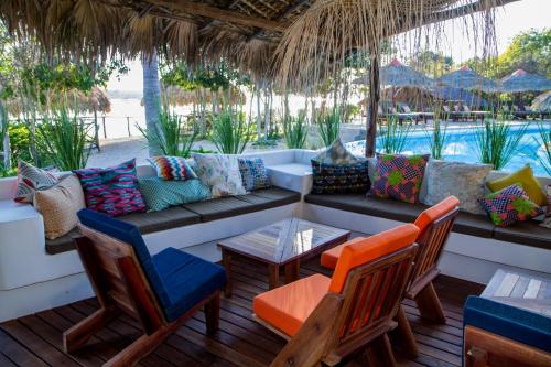 a patio with a couch and chairs and a pool at Antsanitia Resort in Mahajanga