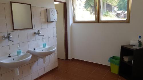 a bathroom with two sinks and a mirror and a window at Wodolenka in Hrádek