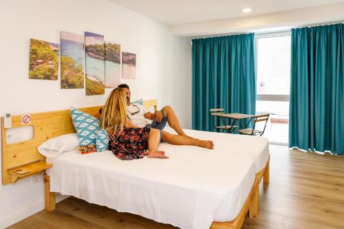 a woman sitting on a bed in a room at We Hostel Palma - Albergue Turístico in Palma de Mallorca