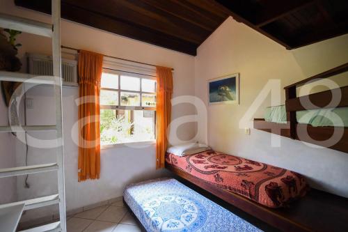 ein Schlafzimmer mit einem Bett und einem Fenster in der Unterkunft Beach House - Camburi in Camburi