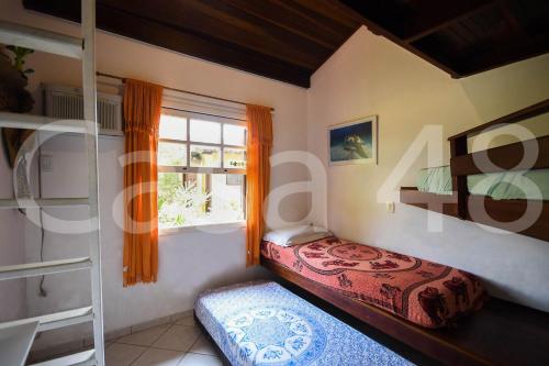 a bedroom with a bed and a window at Beach House - Camburi in Camburi