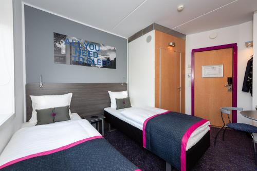une chambre d'hôtel avec deux lits et une table dans l'établissement Cabinn Aalborg, à Aalborg
