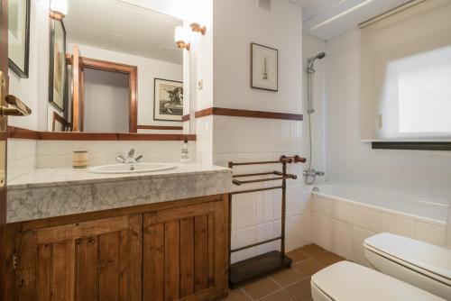 a bathroom with a sink and a toilet and a tub at Noguera by Totiaran in Baqueira-Beret