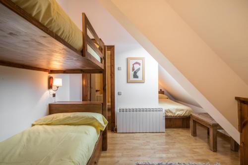 une chambre avec deux lits dans un grenier dans l'établissement Noguera by Totiaran, à Naut Aran