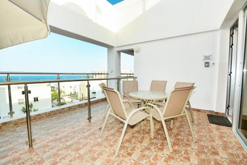 a balcony with a table and chairs and a view of the ocean at Seafront Protaras Apartments in Protaras