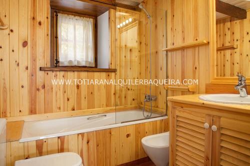 y baño con bañera y lavamanos. en Casa Er Os by Totiaran en Baqueira-Beret