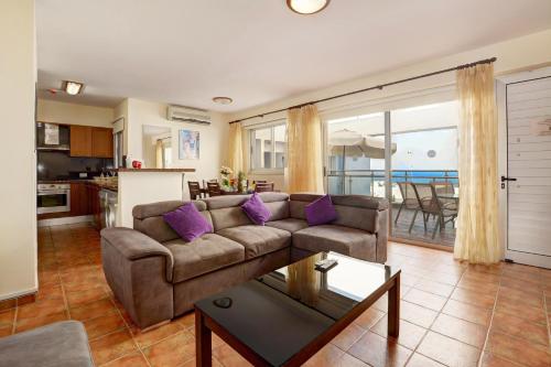 a living room with a couch and a table at Seafront Protaras Apartments in Protaras