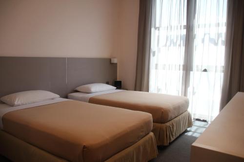 新加坡的住宿－Classique Hotel，配有窗户的酒店客房内的两张床