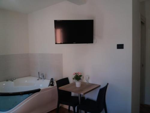 a bathroom with a tub and a table and a tv at Pigneto Square Home in Rome