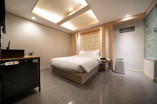a bedroom with a bed and a desk and a bed sidx sidx sidx at Suwon Sunstar Hotel in Suwon