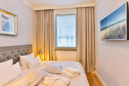 a bedroom with a bed with two towels on it at Magnolia in Ostseebad Sellin