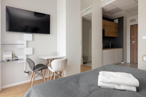 a bedroom with a bed and a tv on the wall at Wola Chic Silver Studio in Warsaw