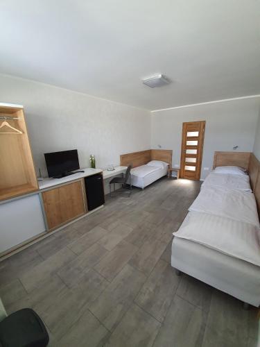 Habitación con 2 camas, escritorio y TV. en Penzion M.L.K en Hlohovec