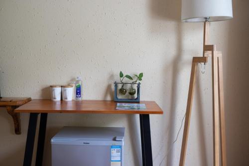 a table with a lamp and a plant on it at Moganshan Bamboo View Guesthouse in Deqing