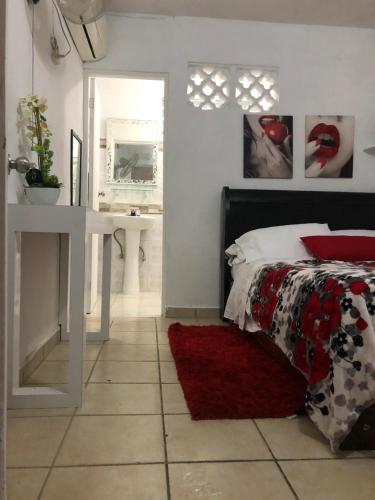 a bedroom with a bed and a table with a red rug at Gavidias Guest House in San Lorenzo