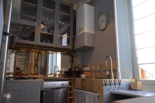 a kitchen with a sink and a clock on the wall at Villa Moncoeur in Le Blanc