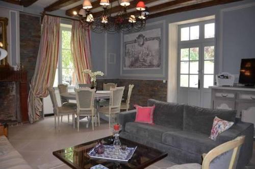 a living room with a couch and a table at Villa Moncoeur in Le Blanc