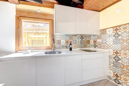 a white kitchen with a sink and a window at ~SILVER~ Edificio Singular S.XVIII. Centro in Toledo