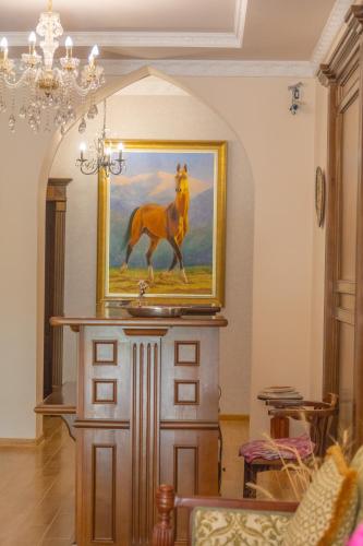a painting of a horse on a wall in a living room at L'Argamak in Samarkand