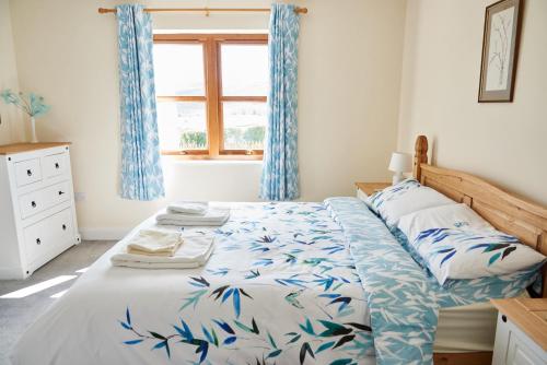 a bedroom with a bed with blue curtains and a window at Finest Retreats - Quail's Nest Cottage in Edlingham