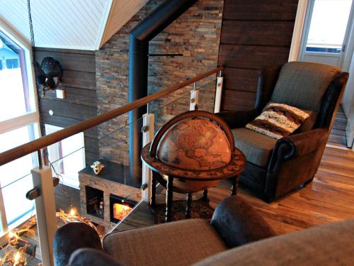 a living room with a couch and a chair and a fireplace at Ottsjö Bear Lodge in Ottsjö