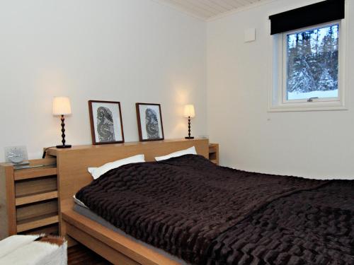 a bedroom with a bed and two lamps and a window at Ottsjö Bear Lodge in Ottsjö
